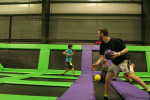 Four Dodgeball Players Grabbing Foam Balls in Trampoline Arena Game